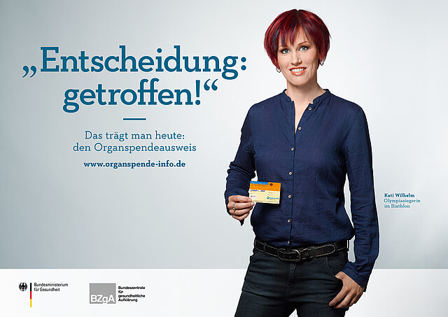 Plakat: Kati Wilhelm mit ihrem Organspendeausweis