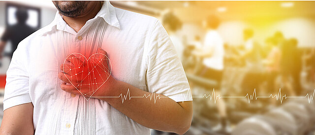 Foto/Grafik: Mann fasst sich an die Brust, darüber gezeichnet: Herz mit Puls-Diagramm