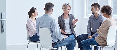 Menschen während einer Therapiestunde - Förderung suizidpräventiver Kompetenz in Institutionen und Gesellschaft (suiKom)