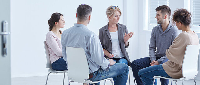 Menschen während einer Therapiestunde - Förderung suizidpräventiver Kompetenz in Institutionen und Gesellschaft (suiKom)
