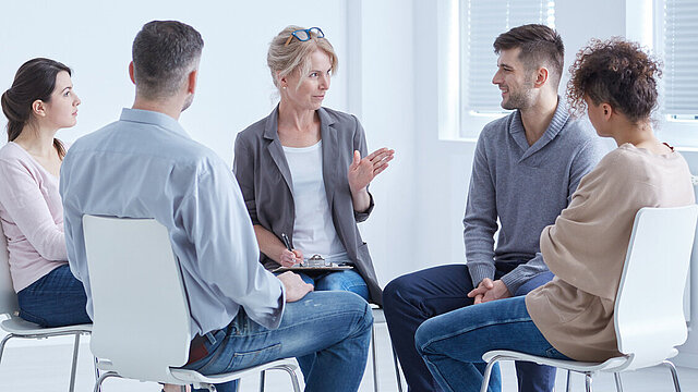 Menschen während einer Therapiestunde - Förderung suizidpräventiver Kompetenz in Institutionen und Gesellschaft (suiKom)