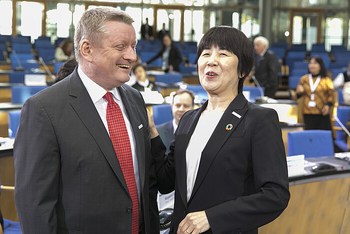 Foto: Naoko Yamamoto und Hermann Gröhe lachend beim Gespräch im Konferenzsaal