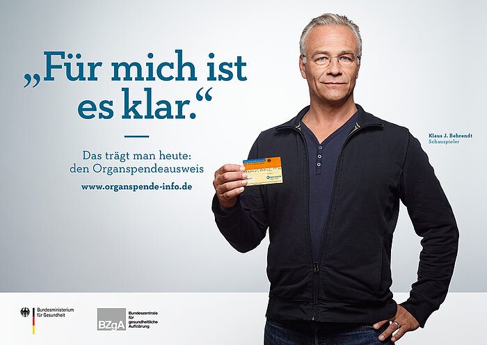 Plakat: Klaus Behrendt mit seinem Organspendeausweis