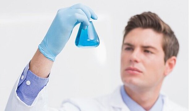 Foto: Arzt hält Reagenzglas hoch
