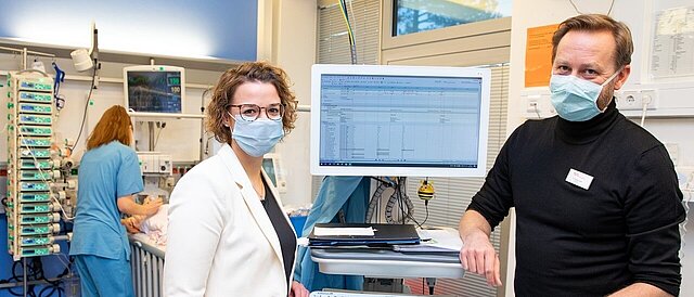 Dr. Thomas Jack und Dr. Antje Wulff neben einem PDMS-Monitor auf der Kinderintensivstation