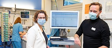 Dr. Thomas Jack und Dr. Antje Wulff neben einem PDMS-Monitor auf der Kinderintensivstation