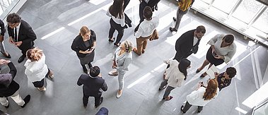 Vielfältige Berufsgruppen bei Networking-Veranstaltung. In einem modernen Konferenzsaal nutzen die Teilnehmer Laptops und Notizblöcke.