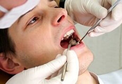Ein Patient mit geöffnetem Mund wird von einem Zahnarzt untersucht
