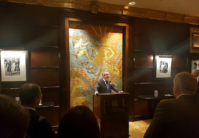 Foto: Minister Gröhe hält eine Rede; im Hintergrund ist eine dunkel vertäfelte Holzwand und ein bestickter Wandbehang zu sehen