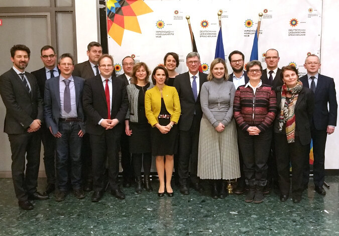 Gruppenfoto der Teilnehmer vor einem Aufsteller mit Logos des Deutsch-ukrainischen Sprachenjahrs