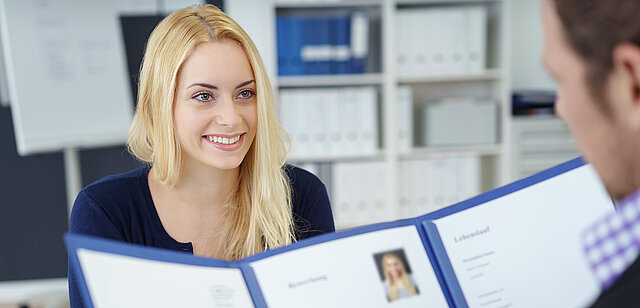 Eine lächelnde junge Frau im Bewerbungsgespräch