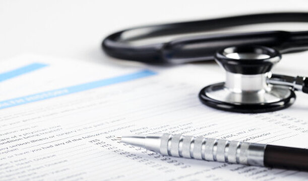 Foto: Ein Stetoskop und ein Kugelschreiber liegen auf medizinischen Unterlagen.