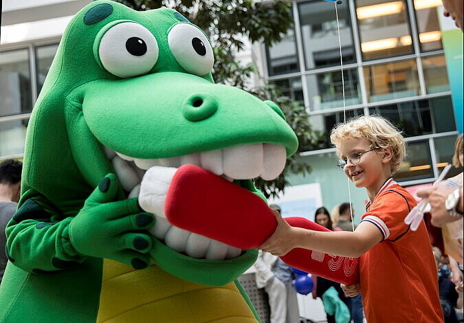 Ein Kind putzt Kroko, dem Zahnputzkrokodil die Zähne