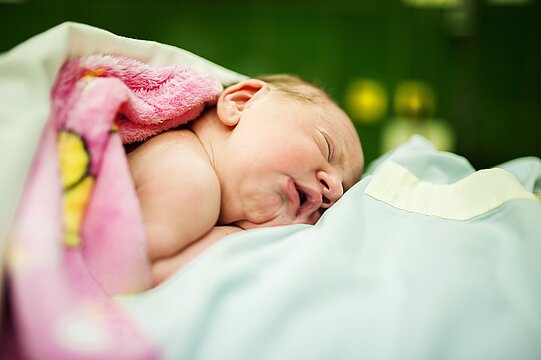 Ein neugeborenes Baby, eingewickelt in eine Decke