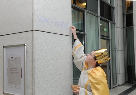 Foto: Ein Mädchen schreibt an eine Säule im Atrium den Segen der Sternsinger
