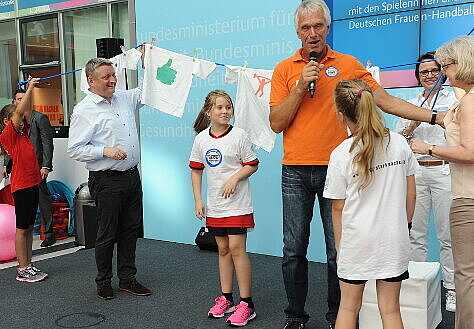 Minister Gröhe und Dr. Heidrun Thaiss hängen Wäsche auf.