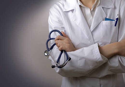 Photo: Doctor with crossing arms in front of her with a med. stethoscope in her hand