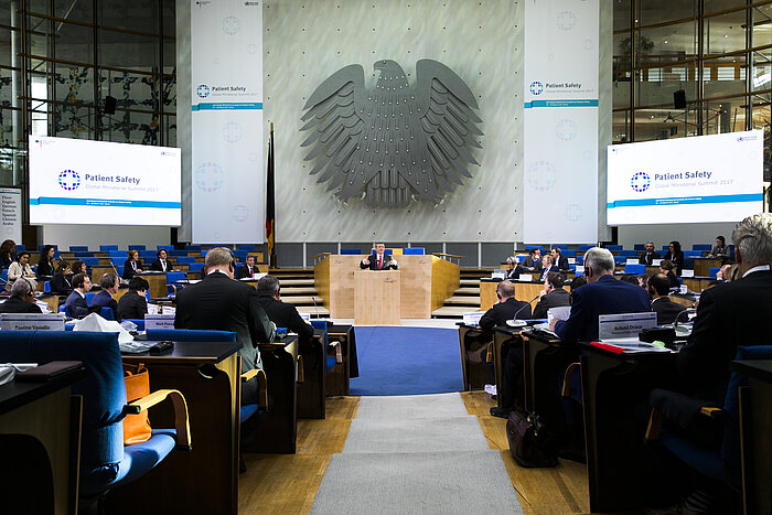 Foto: Hermann Gröhe hält seine Rede, im Vordergrund sind die Zuschauerreihen im Veranstaltungssaal, im Hintergrund der Bundesadler zu sehen