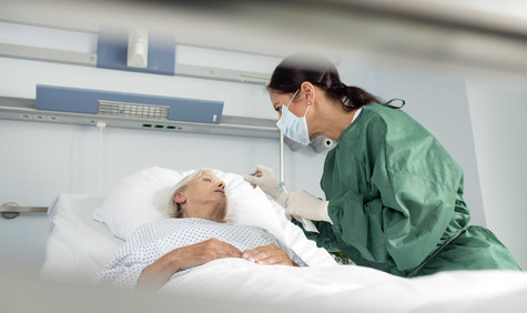 Pflege_im_Krankenhaus Krankenpflegerin beim Mundabstrich.