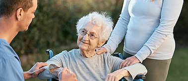 Seniorin im Rollstuh mit Familie