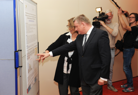 Foto: Bundesgesundheitsminister Hermann Gröhe lässt sich von einer Frau eine Grafik erklären.