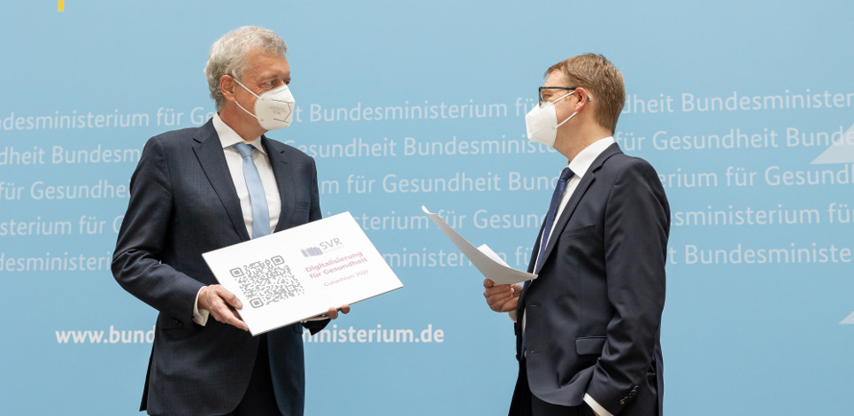 SVR-Vorsitzender Prof. Ferdinand M. Gerlach übergibt das SVR-Gutachten dem parlamentarischen Staatssekretär Dr. Thomas Gebhart (BMG/Frederic Schweizer) SVR-Vorsitzender Prof. Ferdinand M. Gerlach übergibt das SVR-Gutachten dem parlamentarischen Staatssekretär Dr. Thomas Gebhart